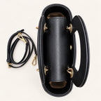 Structured black vegan leather and Zhuang brocade handbag, side view
