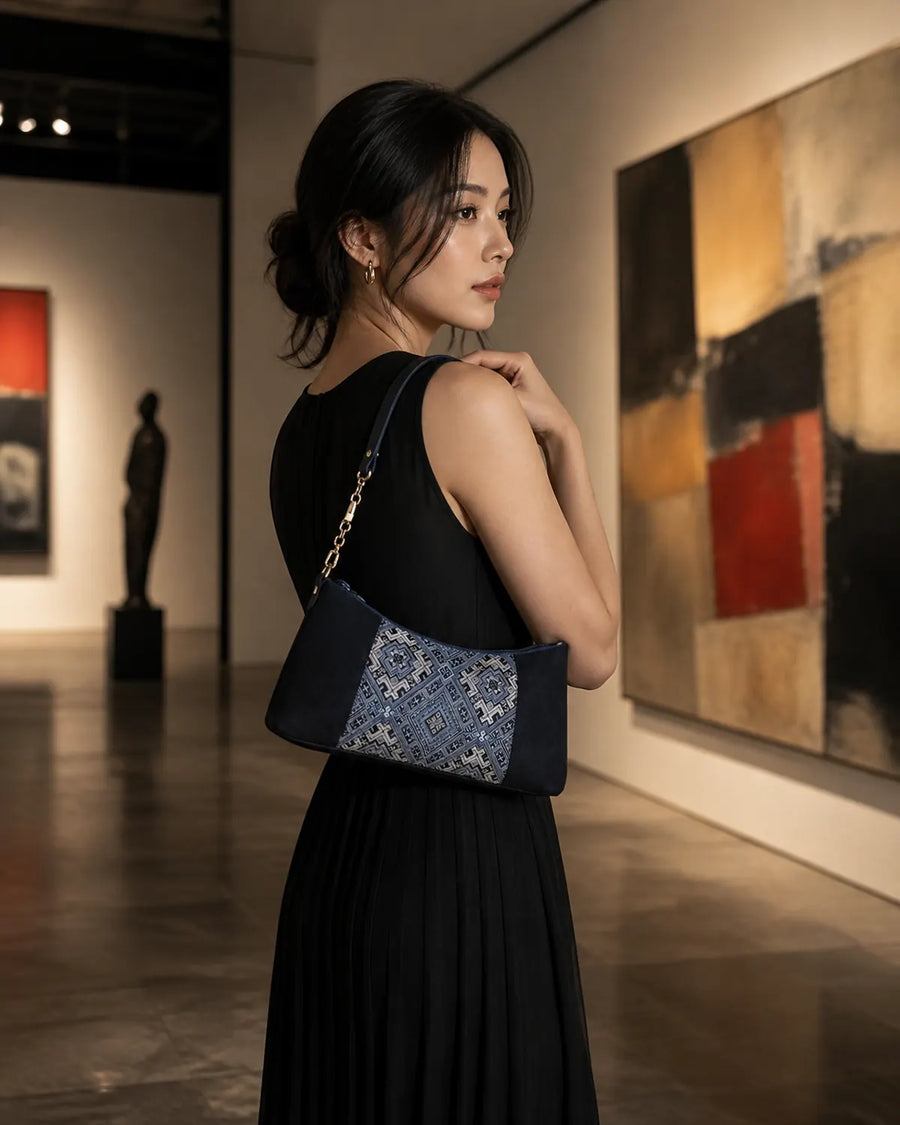 Woman wearing a navy brocade baguette bag under her arm